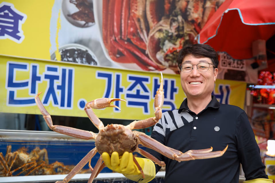 기장 청해왕대게 정영진 대표가 매장 앞에서 활대게를 직접 들고 있는 사진